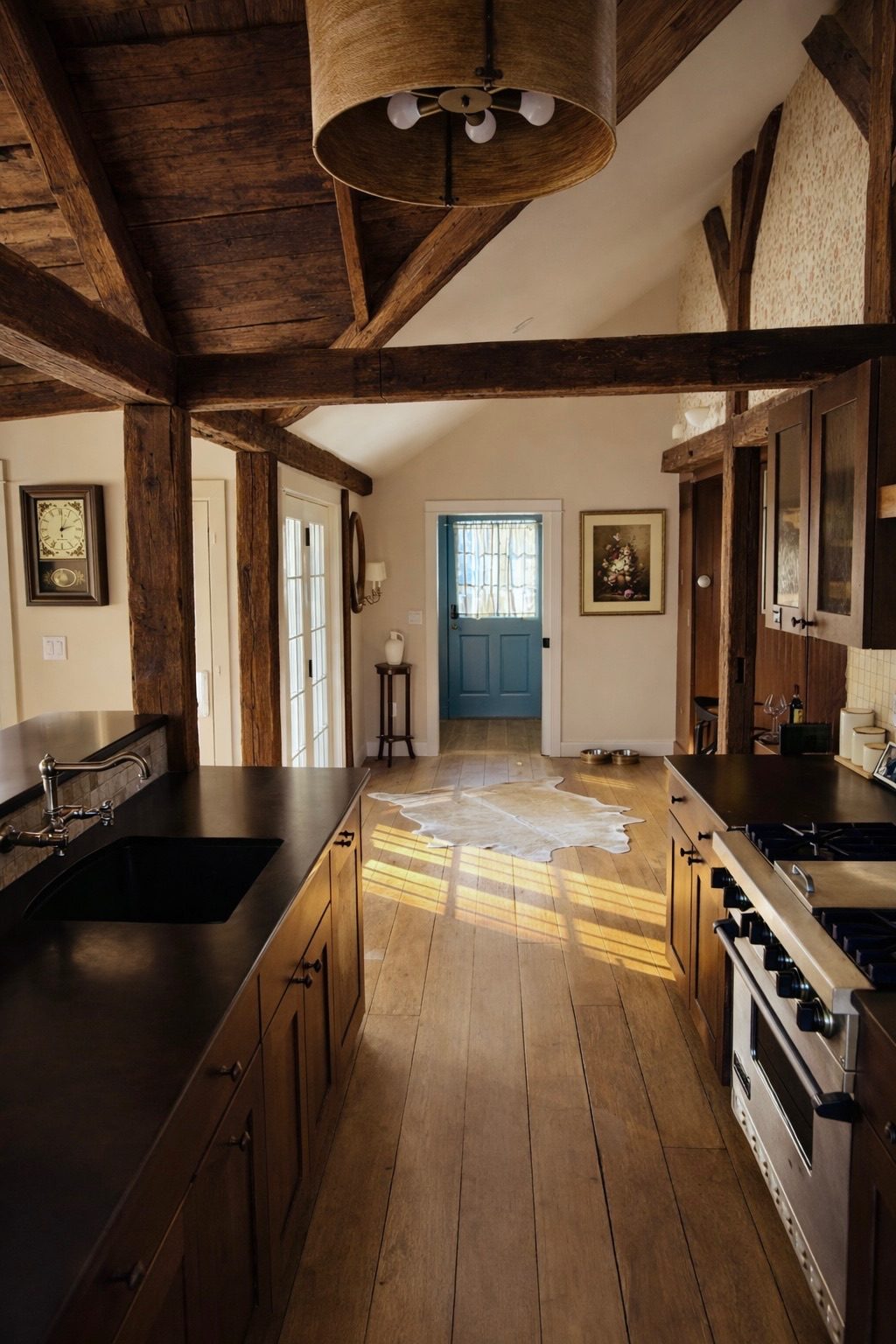 Farmhouse kitchen with hand hewn beams and blue Dutch door