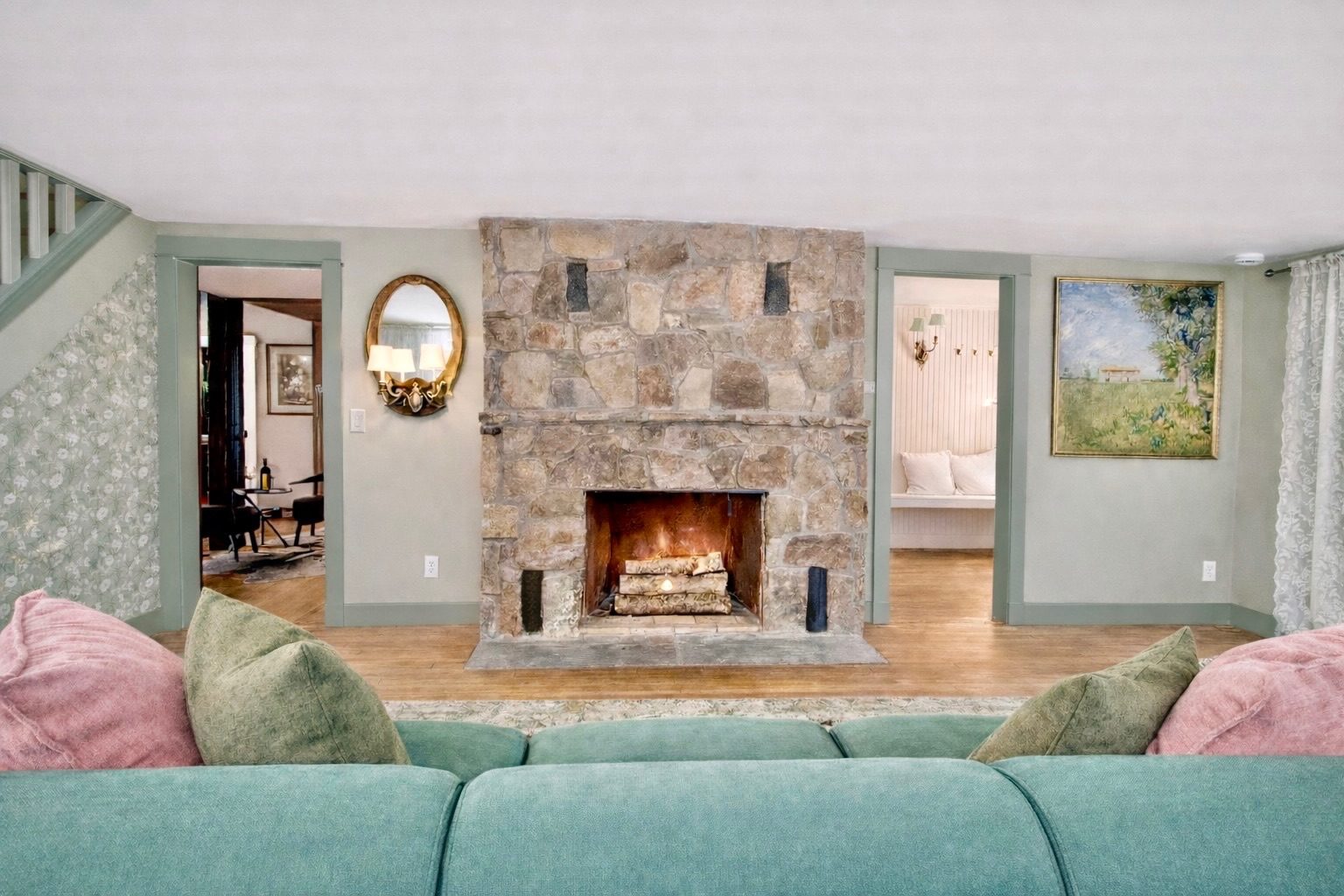 Living room with a lit stone fireplace in the Hudson Valley farmhouse rental